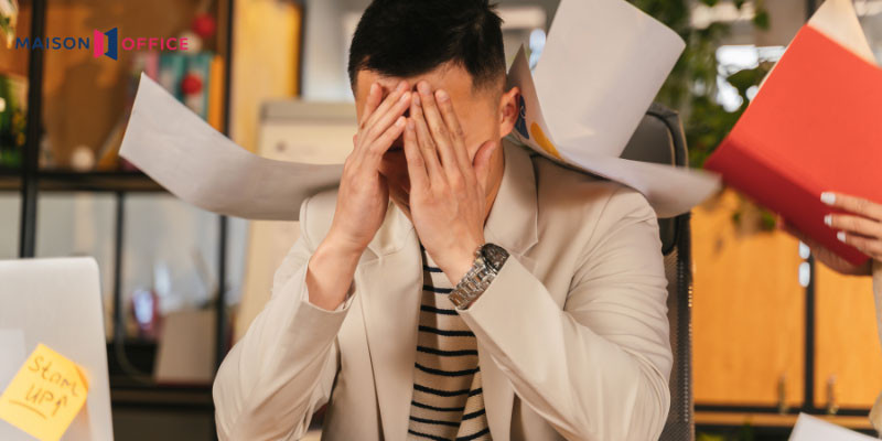 alt: Hình ảnh minh họa về stress trong công việc, một người đang ngồi làm việc với vẻ mặt căng thẳng và mệt mỏi